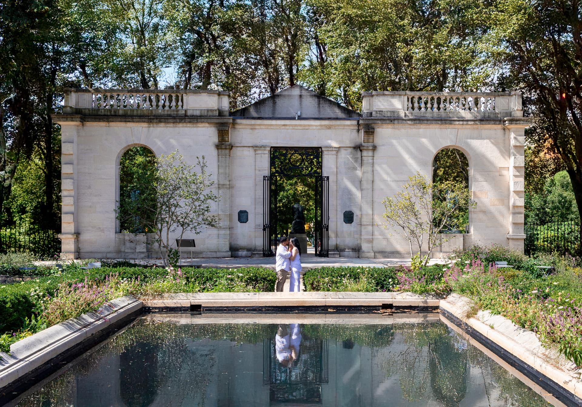 Angel & Val kissing beside a reflecting pool